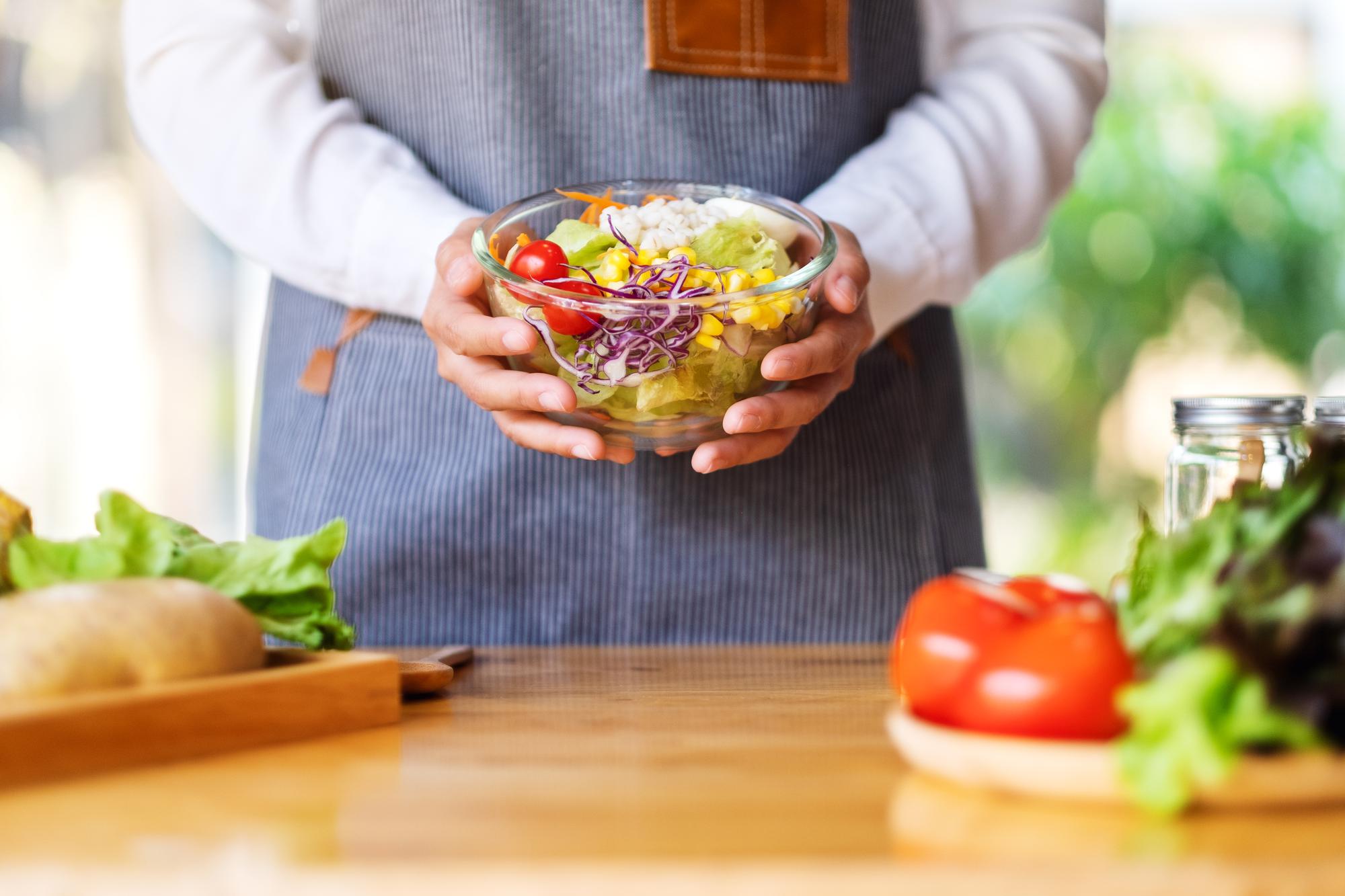 Cook preparing a simple seasonal salad in bright kitchen